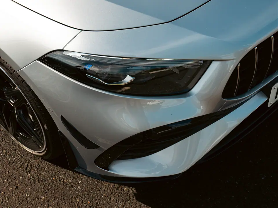 Headlight and front splitter of a silver Mercedes-AMG A-Class