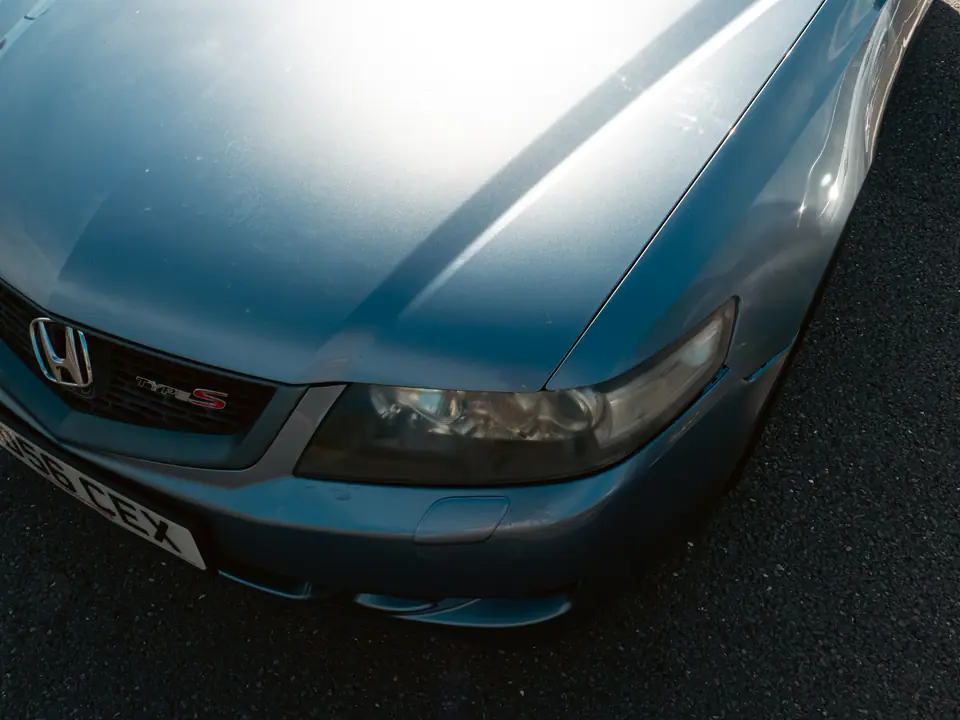 Front corner and badge of a grey Honda Accord