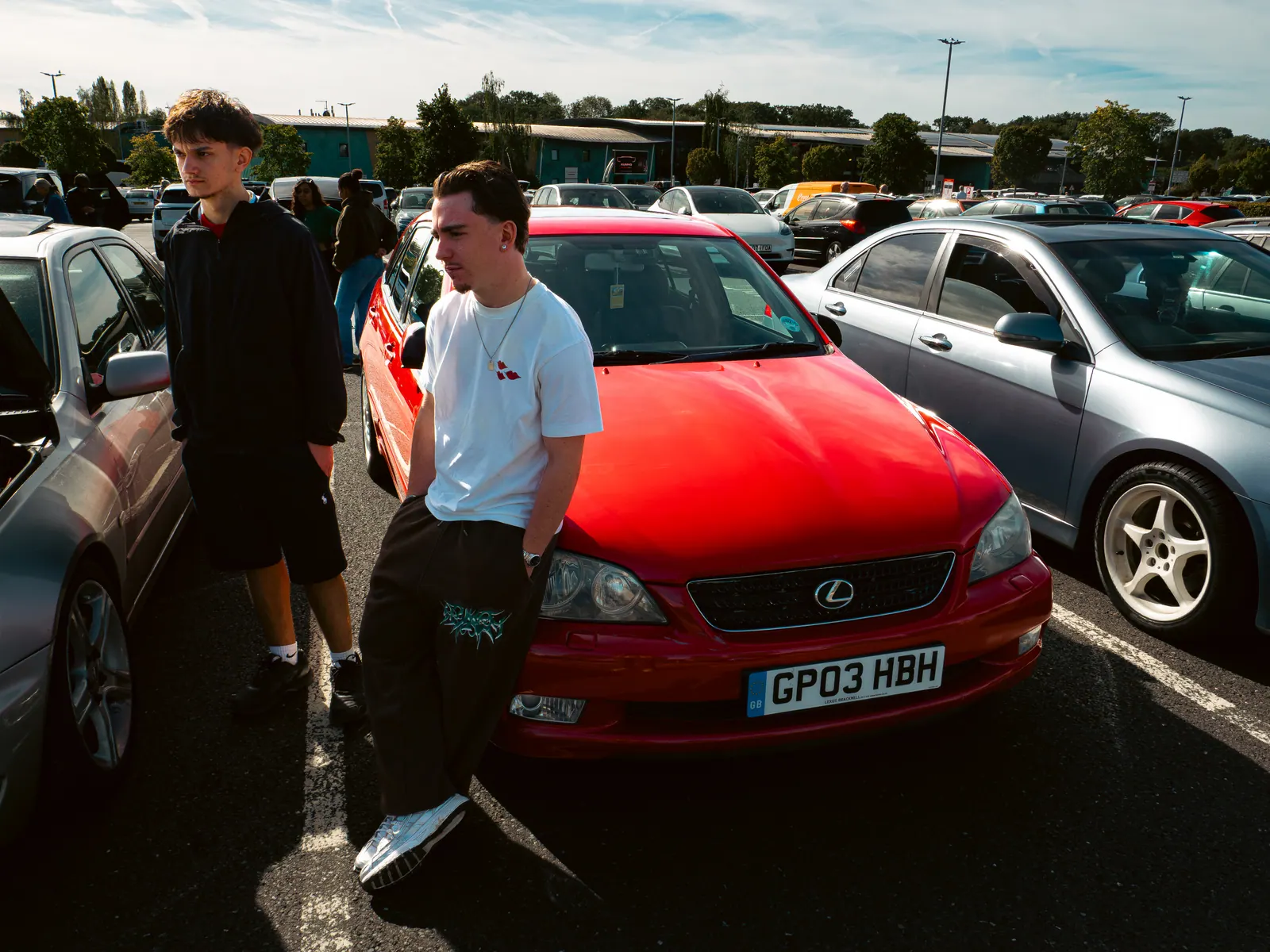 Two friends with a red Lexus IS