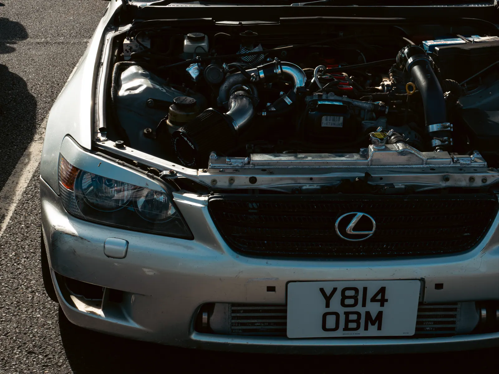 Engine bay of a silver Lexus IS, bonnet up