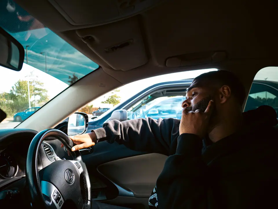 Driver on the phone, one hand on the wheel, before setting off