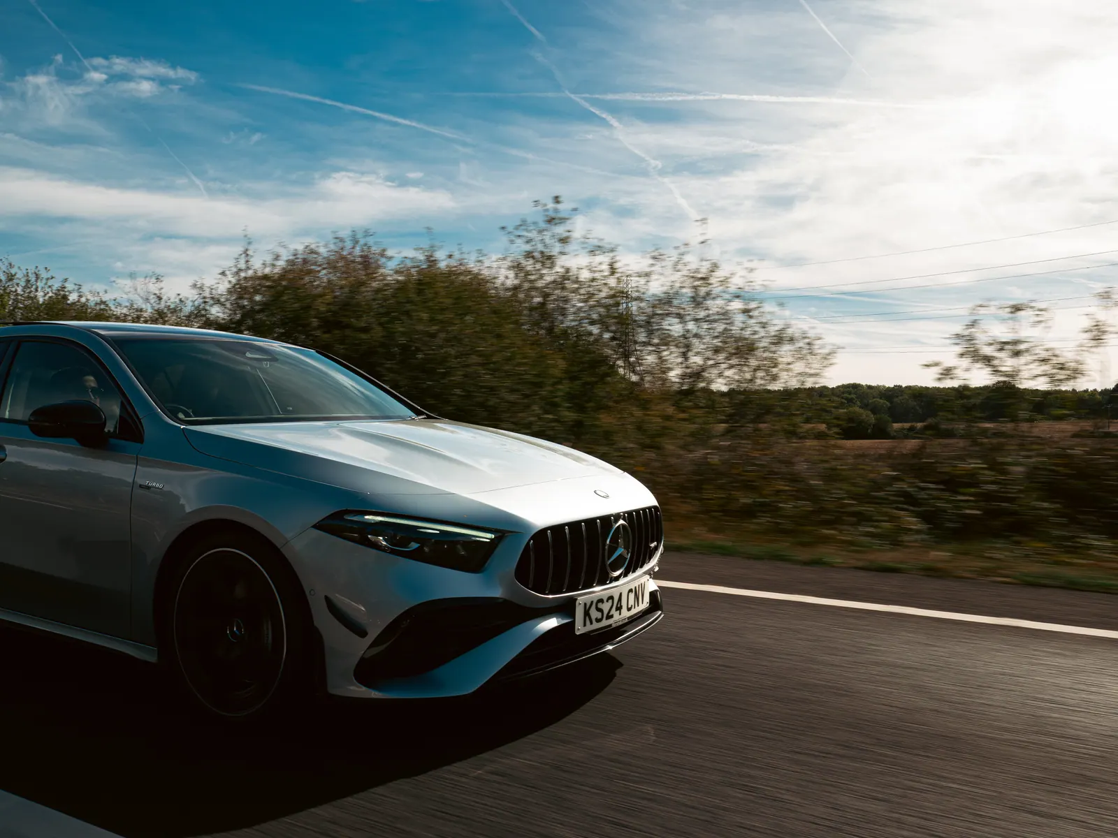 Silver Mercedes-AMG A-Class rolling under a big sky