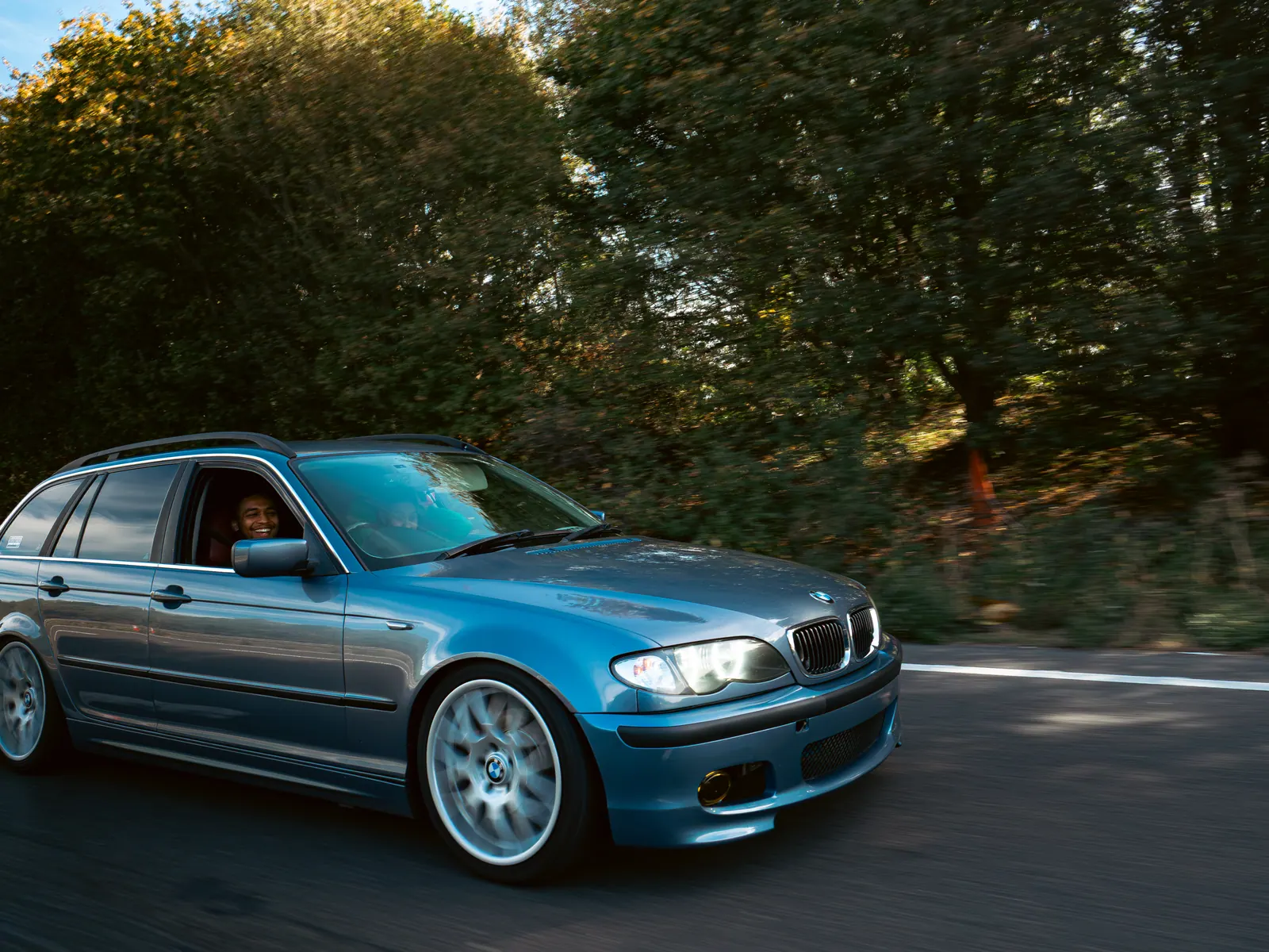 Blue BMW 3 Series Touring in low autumn sun