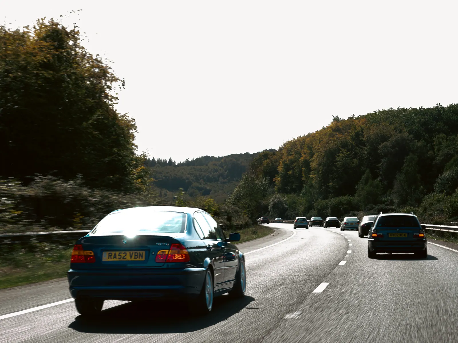 Blue BMW 3 Series saloon leading the line down the motorway
