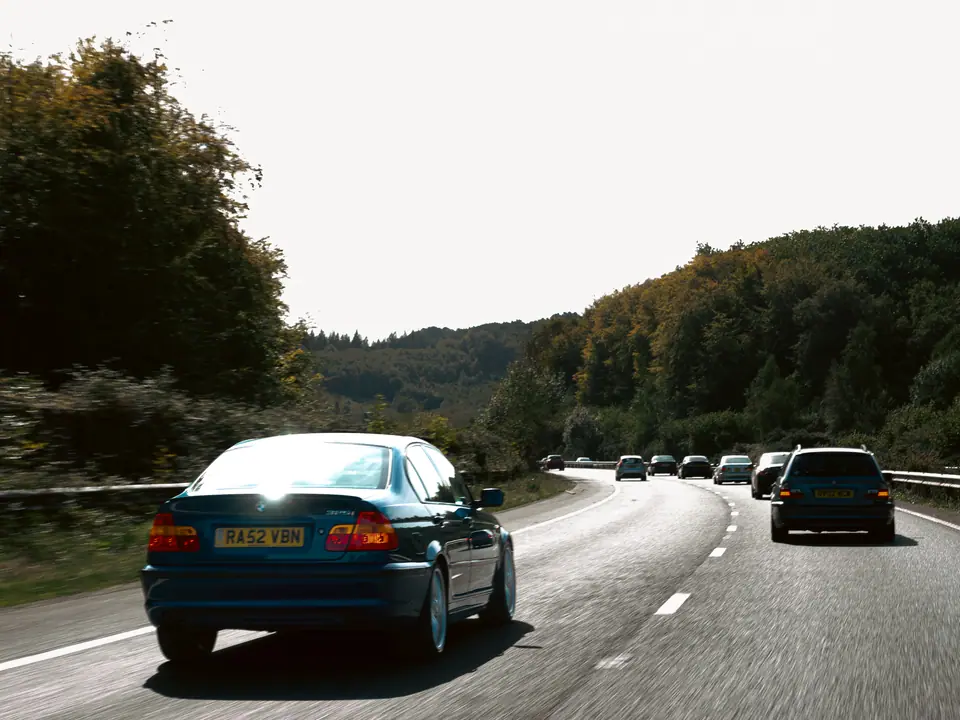 Blue BMW 3 Series saloon leading the line down the motorway