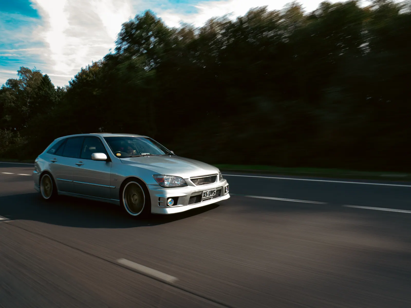 Silver Lexus IS SportCross rolling down an empty lane