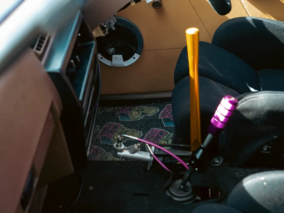 Gold shifter extension and purple gear knob in a stripped interior