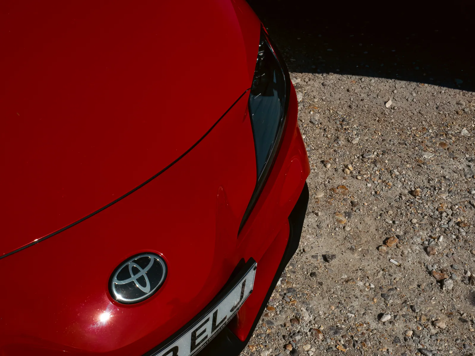 Toyota badge on the nose of a red GR Supra