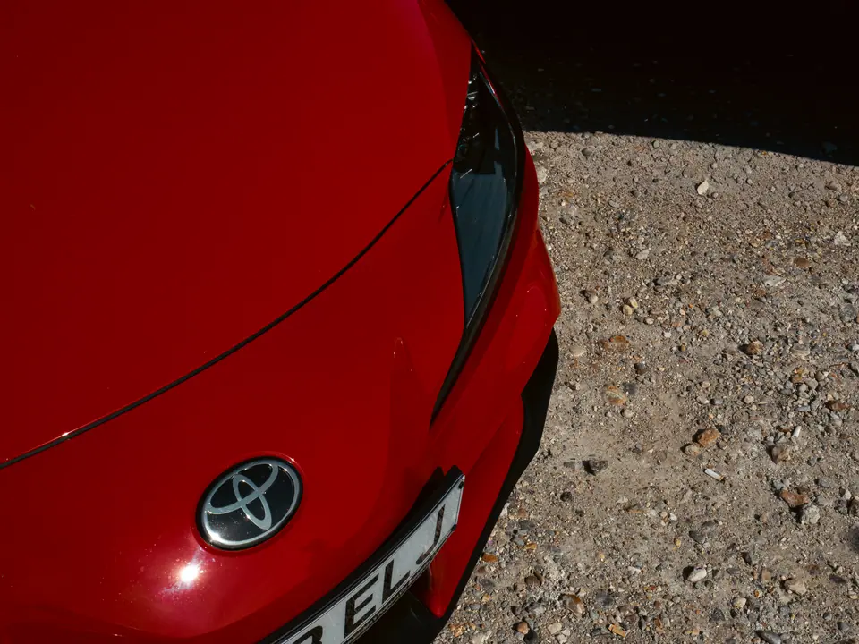 Toyota badge on the nose of a red GR Supra