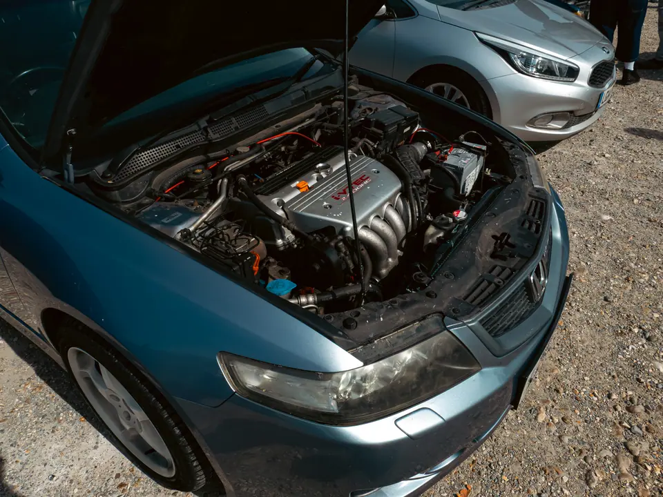 Engine bay of a grey Honda Accord with red cam cover