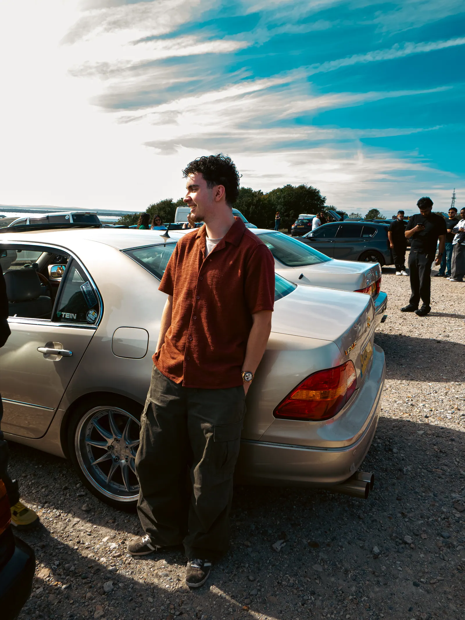 Standing by a gold Lexus LS on aftermarket wheels