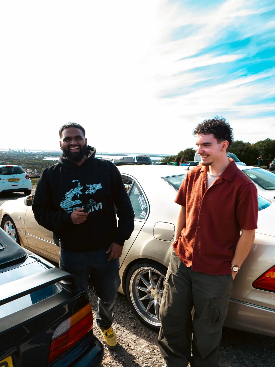 Two friends in front of a gold Lexus LS