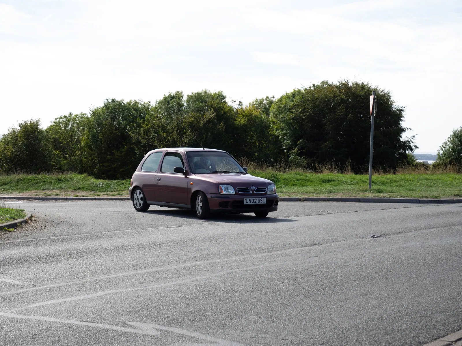 Purple Nissan Micra pulling out of the hilltop car park