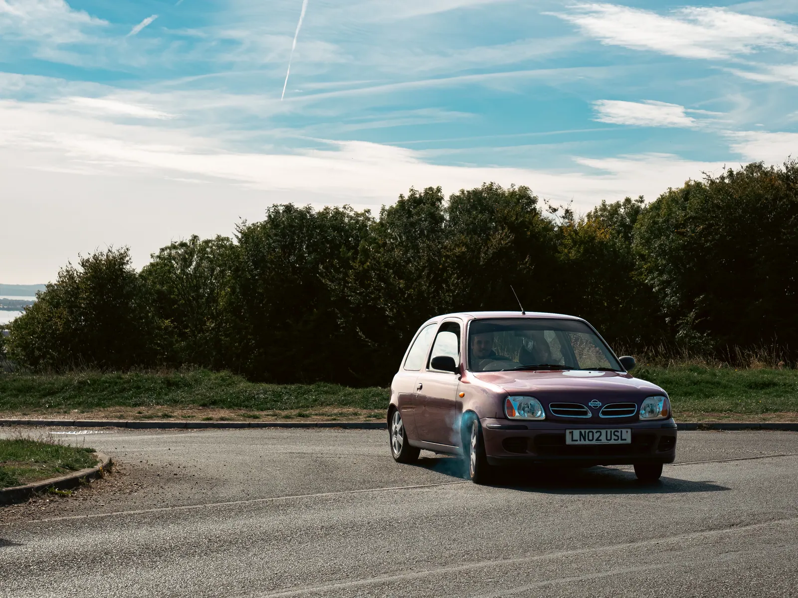 Purple Nissan Micra on the road above the harbour