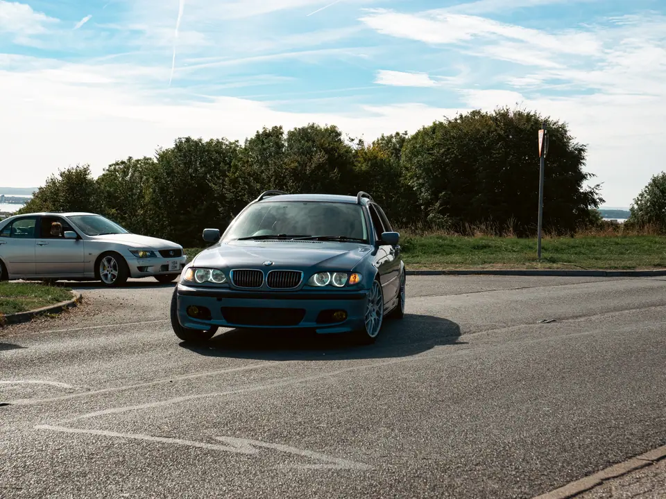 Blue BMW 3 Series Touring with angel-eye headlights