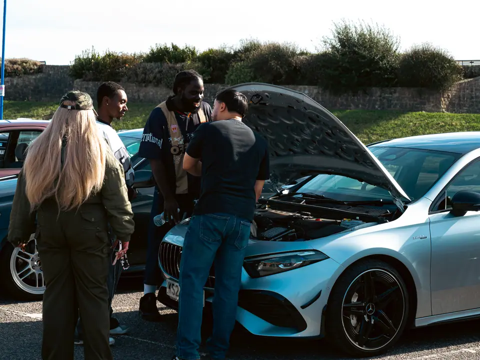 Bonnet up on the silver Mercedes-AMG A-Class, friends looking in