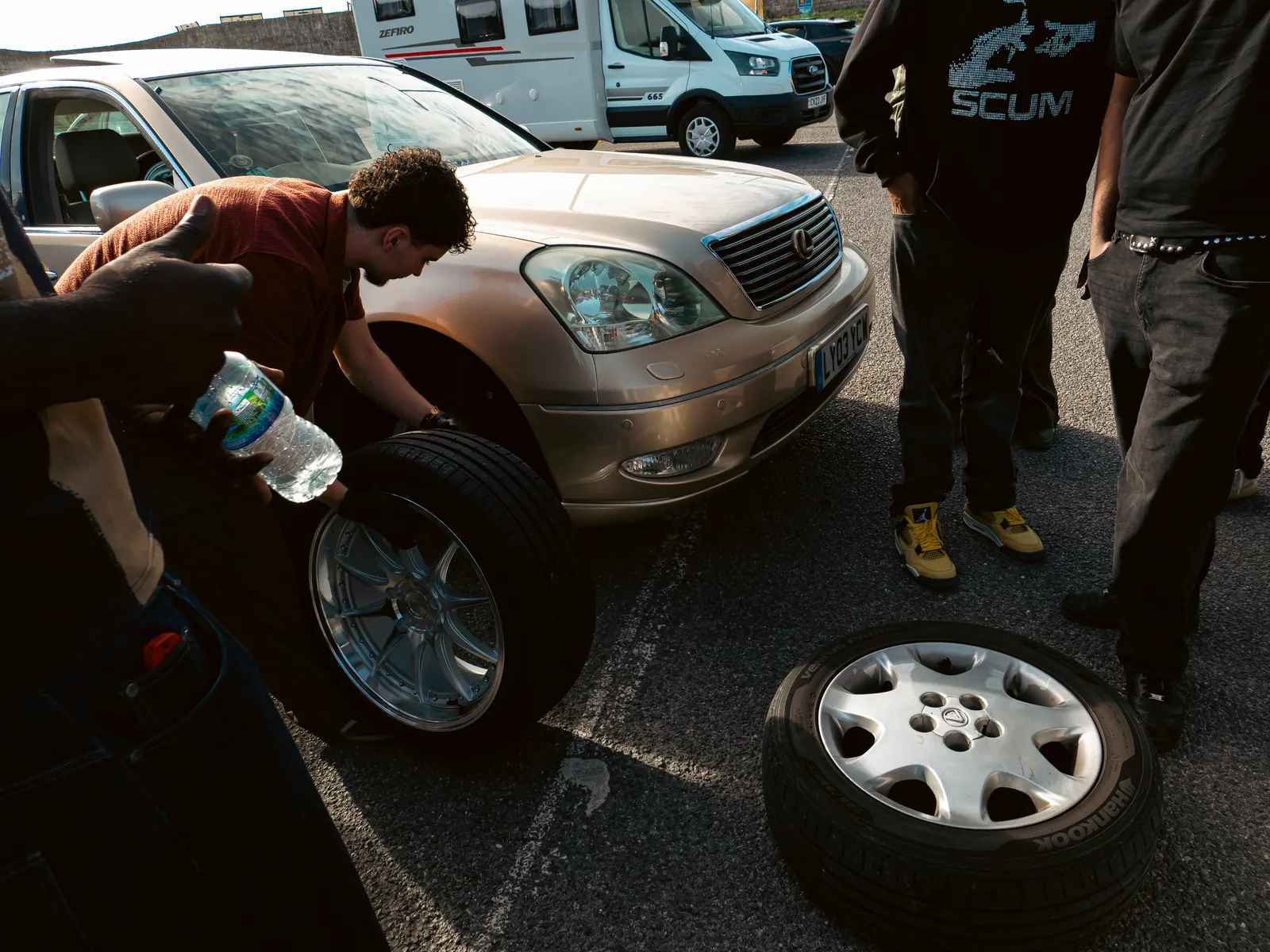 Old wheels off, gold Lexus LS on the jack