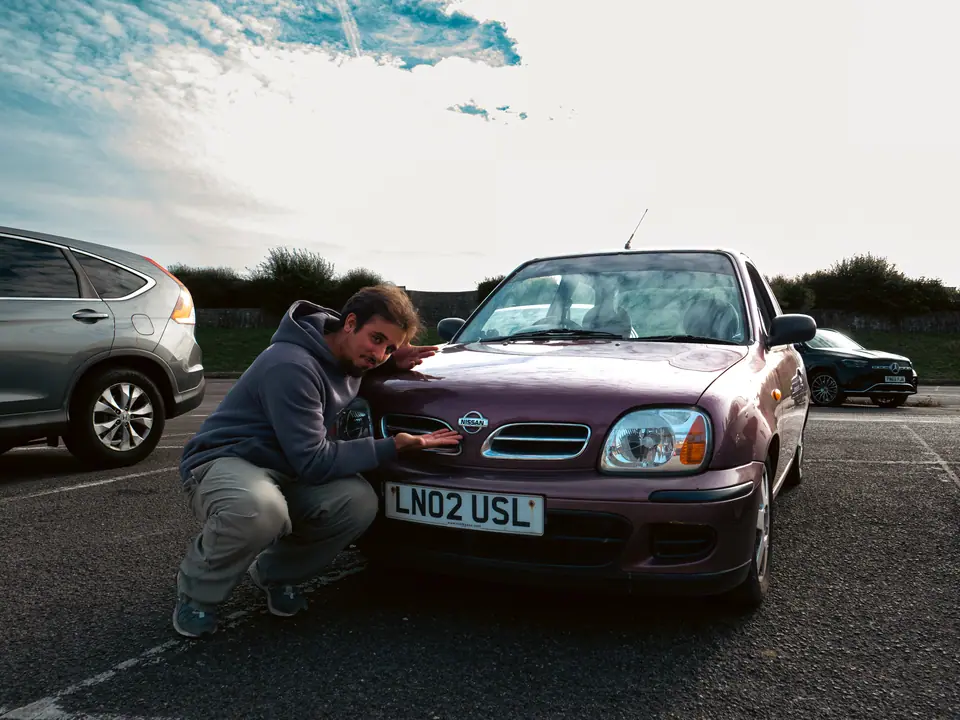 Crouched proudly beside the purple Nissan Micra