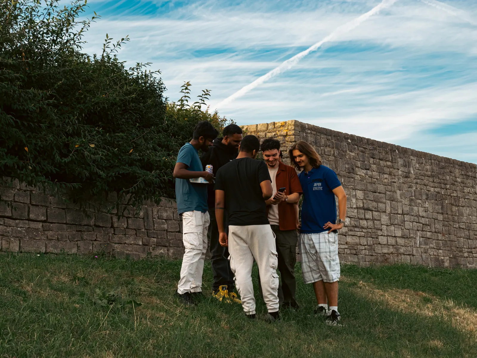 On the grass by the old stone wall