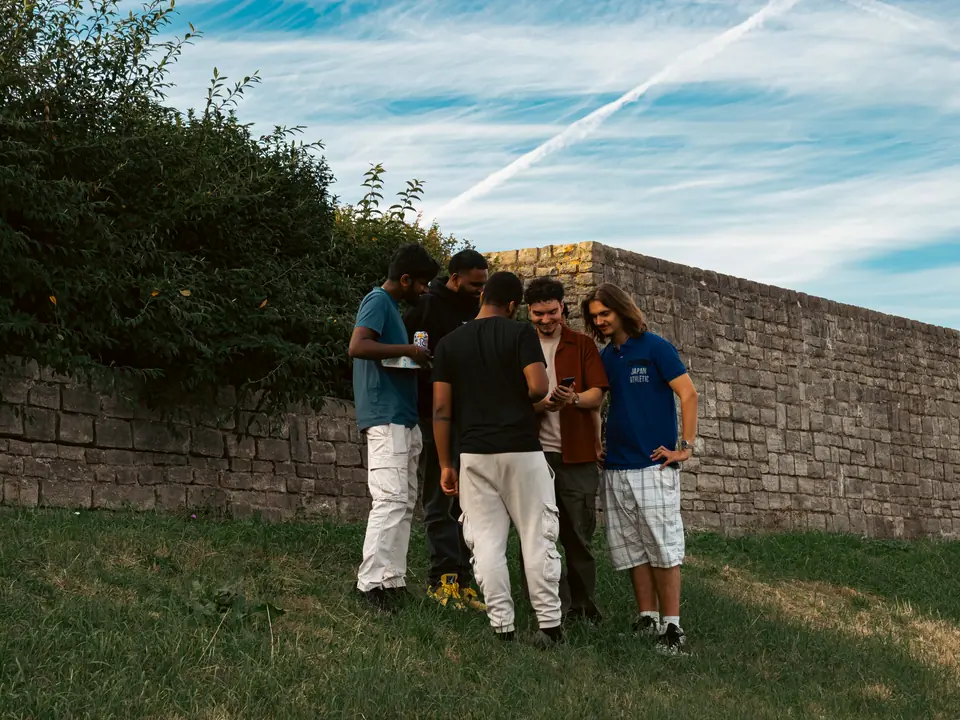 On the grass by the old stone wall