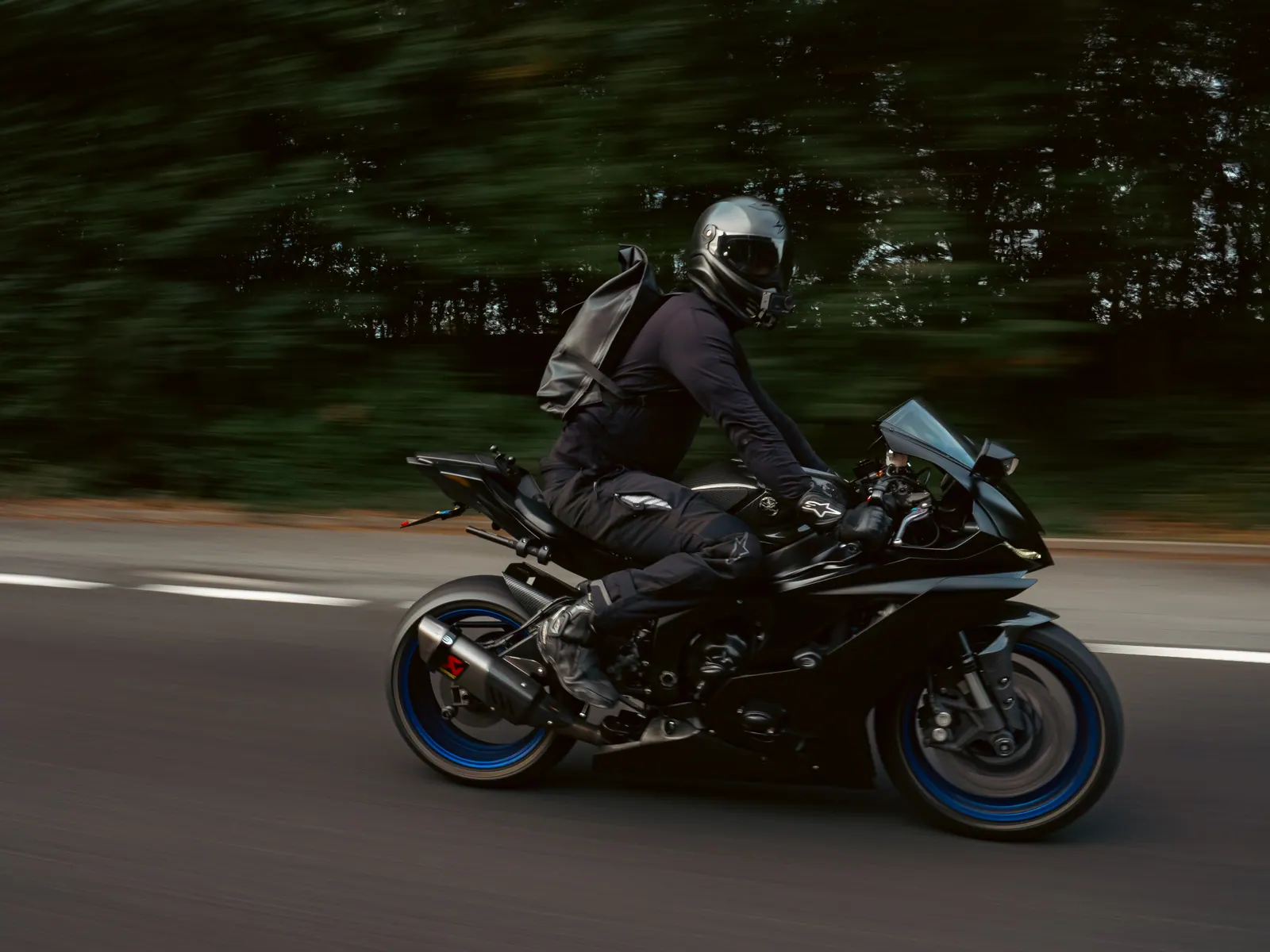 Black sports bike with blue wheels, rolling