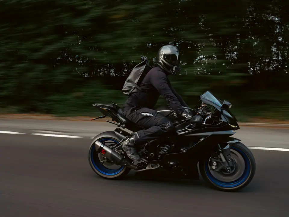 Black sports bike with blue wheels, rolling