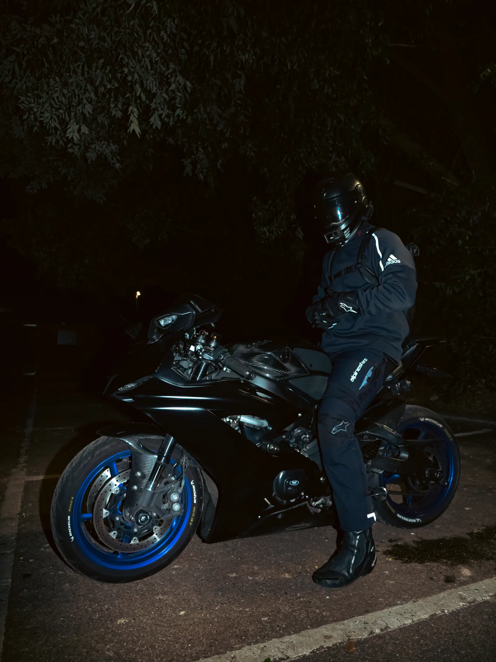 Rider and sports bike at night, portrait